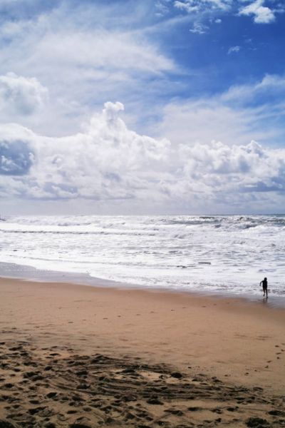 Junge rennt am Strand auf Wellen zu